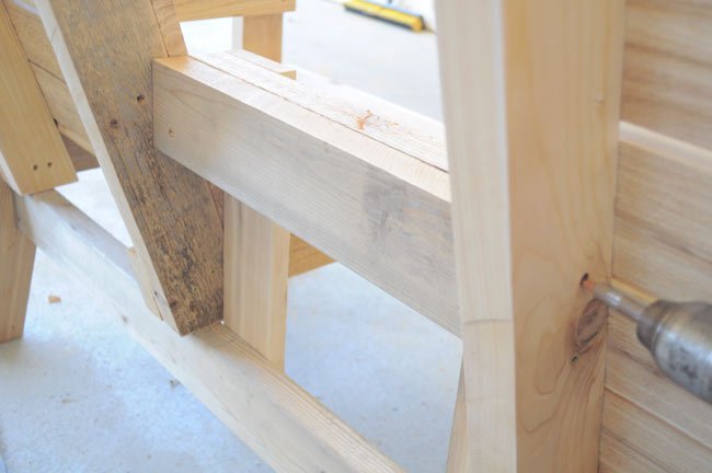 Совмещенные деревянные кресла с подлокотниками и столиком посередине в фото