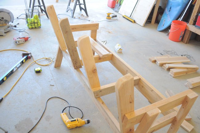 Совмещенные деревянные кресла с подлокотниками и столиком посередине в фото