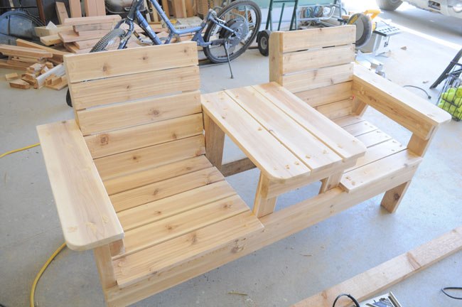 Совмещенные деревянные кресла с подлокотниками и столиком посередине 